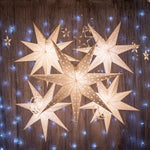 5 white paper star lanterns lit up